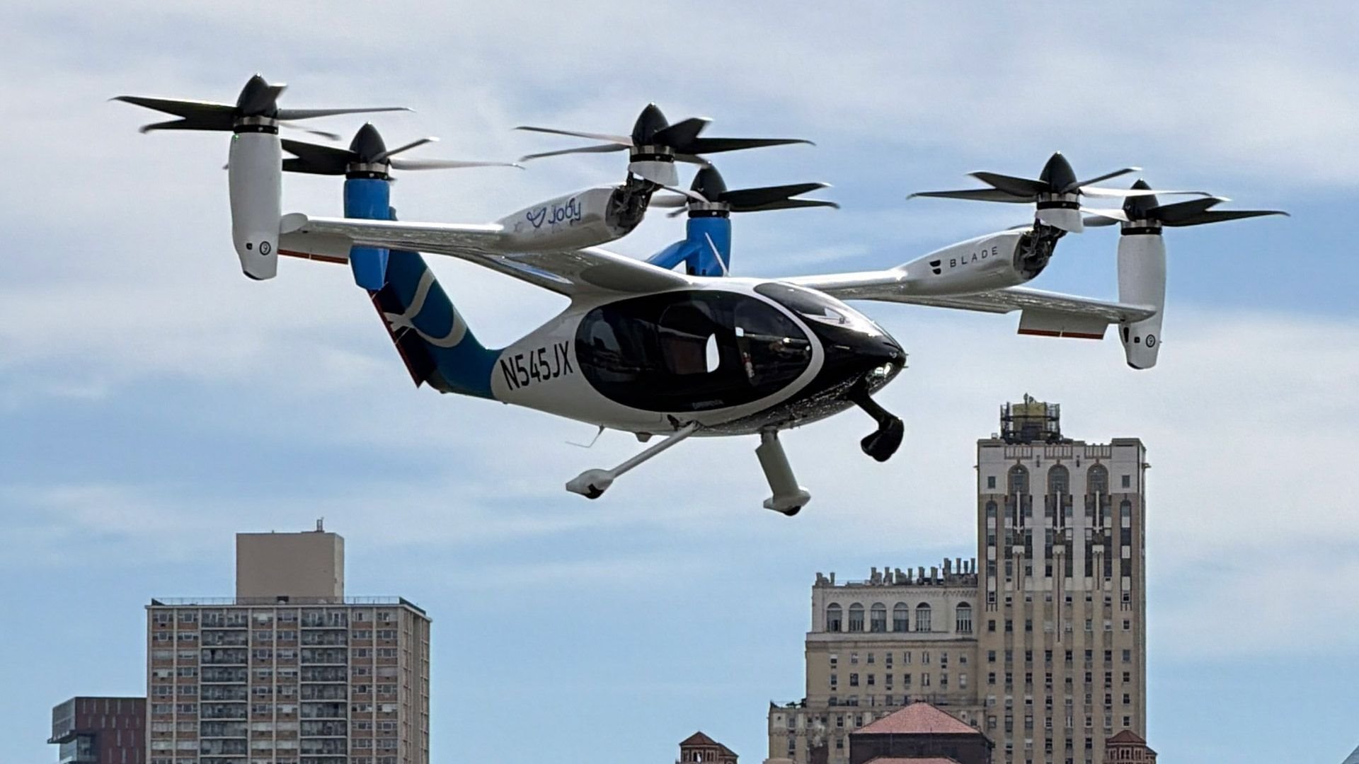 Electric vertical take-off aircraft flying over a city